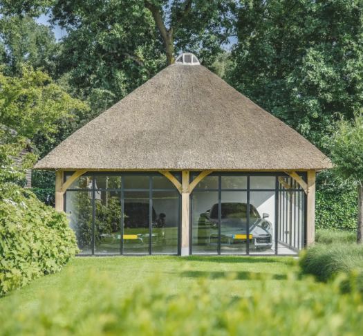 Eiken poolhouse aan het zwembad met rotan loungeset en potplanten