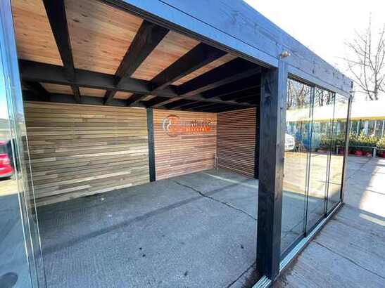 Tuinwand van ipe met zwarte overkapping Ipe latten schutting exlcusief met zwarte staanders in moderne tuin