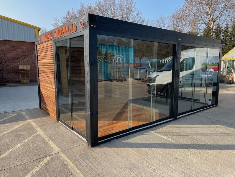 Een moderne zwarte veranda van hout in de tuin met een strakke afwerking