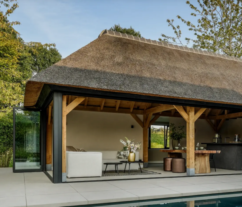 Sfeervol buitenverblijf met een houten overkapping op maat in een groene achtertuin