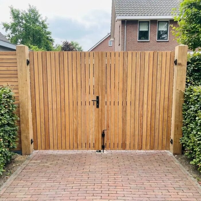 Dubbele teak tuinpoort aan het eind van een oprit