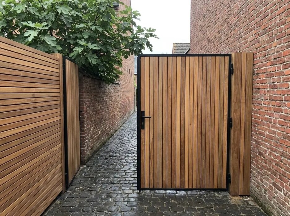 Ipe poort op maat tussen bakstenen muren in een stadstuin