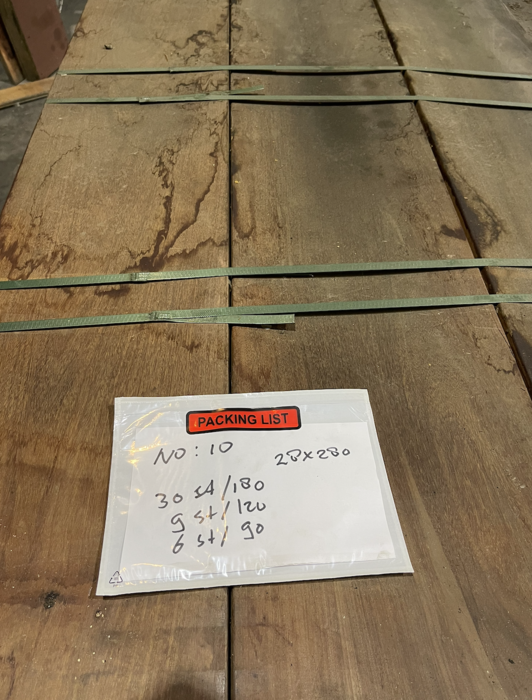 Bovenaanzicht van een voorraad geschaafde hardhouten planken op een pallet in het houtmagazijn