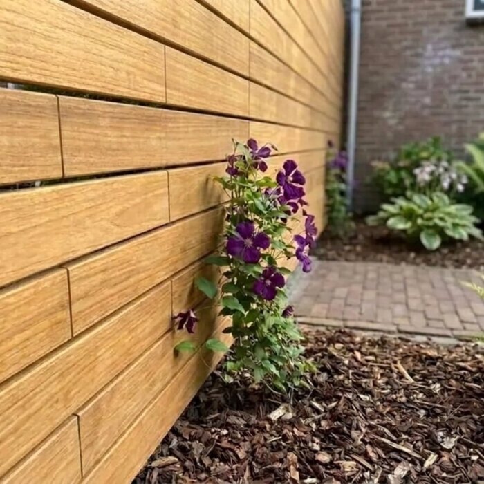Teak lamellen van 7 cm met de clips verborgen in de voeg, bij een azobé paal Teak lamellen van 7 cm met de clips verborgen in de voeg, bij een azobé paal