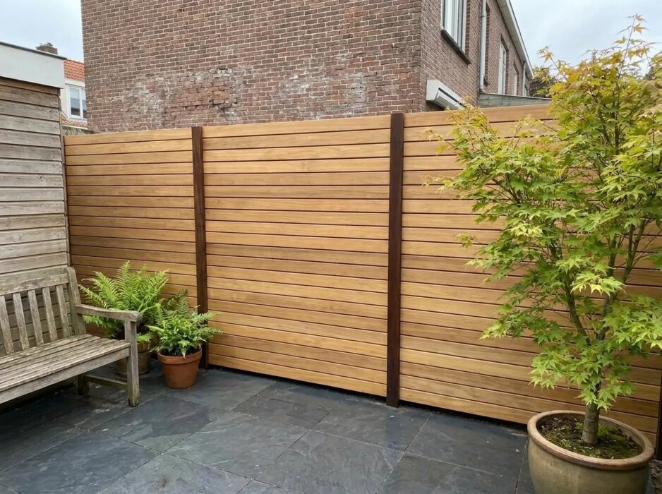 Teak schutting met 9 cm lamellen in een stadstuin met Japanse esdoorn