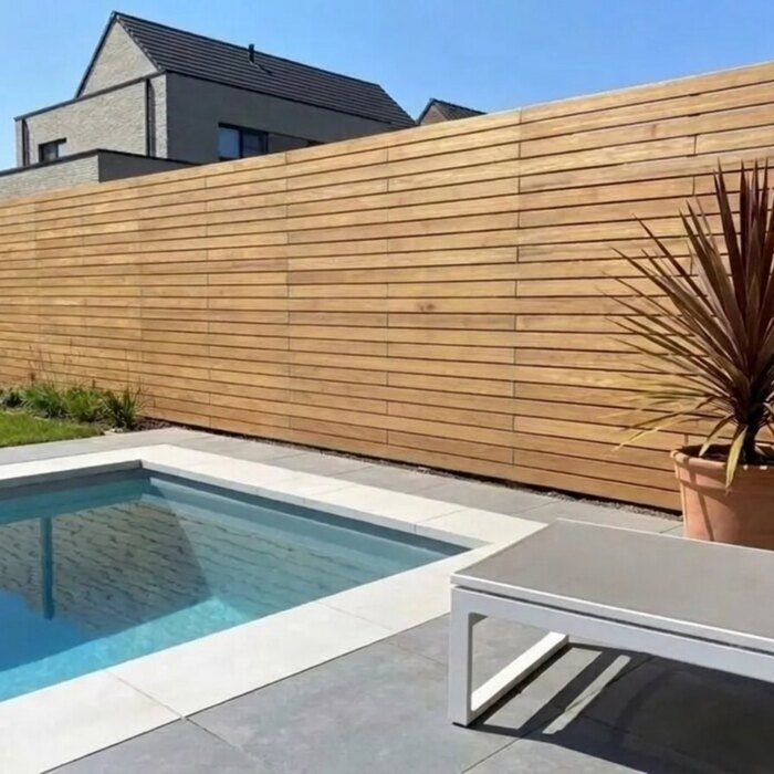Teak schutting met 9 cm lamellen naast een zwembad