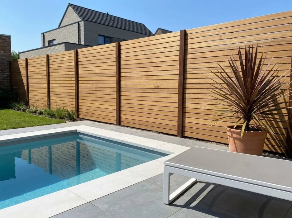 Teak schutting van 9 cm lamellen naast een zwembad in een moderne tuin