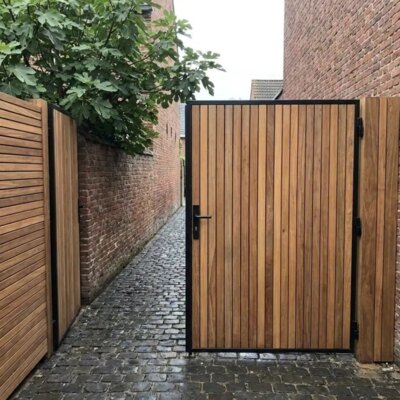 Ipe poort op maat tussen bakstenen muren in een stadstuin