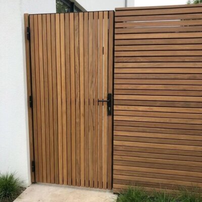 Ipe tuinpoort met lamellen van 5 cm bij de zij-ingang van een villa