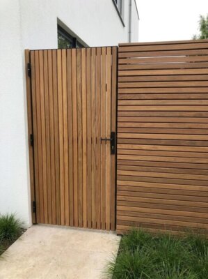 Ipe tuinpoort met lamellen van 5 cm bij de zij-ingang van een villa