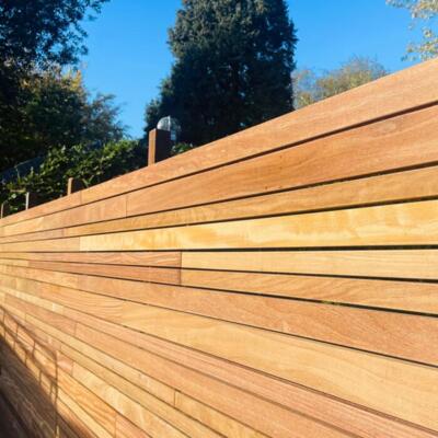 Luxe Ipé hardhout variatie schutting met 5, 7 en 9 cm brede lamellen in een moderne tuin.
