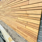 ipe houten modere schutting van hardhout uitgevoerd met lamellen variatie in 3 breedtes 5 cm 7cm en 9 cm.