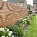 Ipe lamellenwand met 5 cm lamellen als tuinwand achter een border