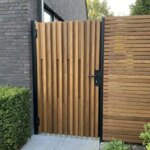 Ipe tuinpoort 4x4 balkjes dubbelzijdig bij een zij-ingang met taxushaag