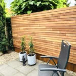 Moderne houten schutting met 7.0 cm lamellen horizontaal gemonteerd met montage clips van ipe hardhout 