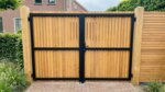 Teak dubbele poort op maat, enkel bekleed, achterkant met zwart frame