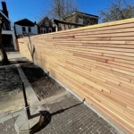 Lange teak schutting met smalle lamellen van 5 cm