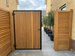 Teak poort op maat in een zijpad, lamellen van 7 cm