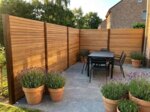 Teak schutting van 7 cm lamellen om een terras met eettafel en lavendel