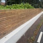 Lage schutting in 5.0 cm ipe lamellen op muur