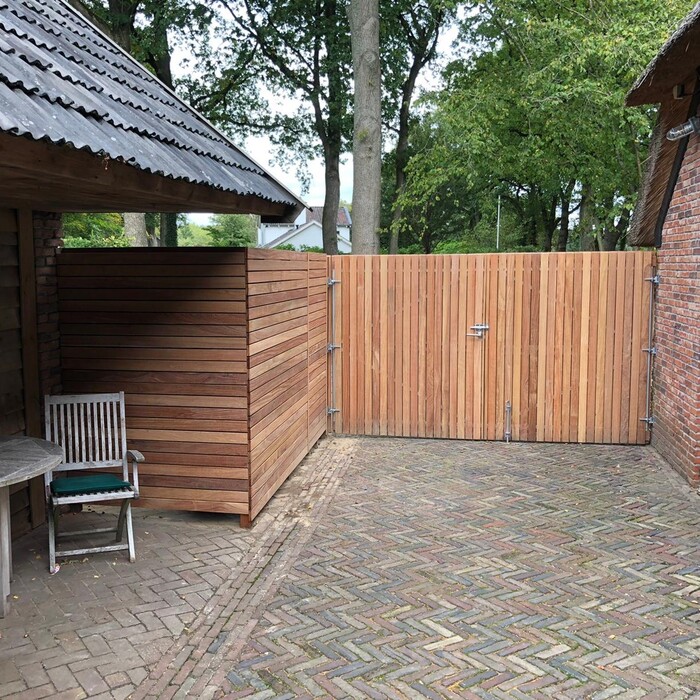 Houten dubbele poort met passend zijstuk in een Ipe schutting