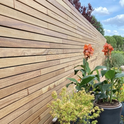 Moderne houten schutting met horizontale lijnen Moderne houten schutting van Ipé hardhout met strakke horizontale lamellen.