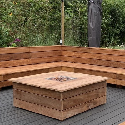 Moderne vuurtafel gecombineerd met Ip&eacute; hardhouten zitbanken in villatuin